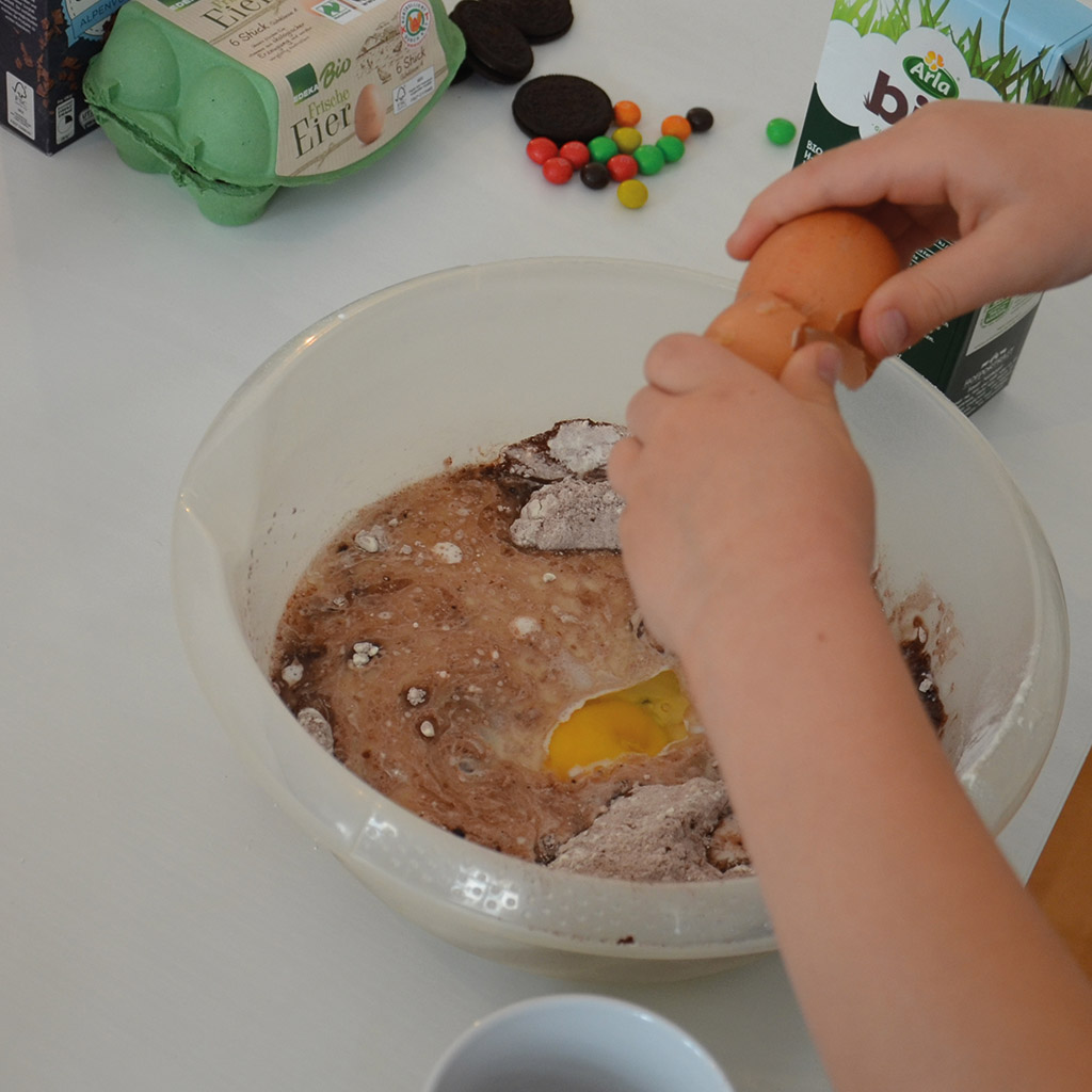 Eulen-Muffins für kleine Zauberer: Ein Ei muss in den Teig.