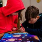Kinder spielen die Weltall-Schatzsuche